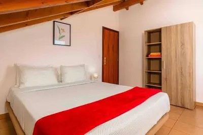 a bedroom with a large bed with a red blanket at Apartment 1BR Hills over Ponta do Sol, sea view in Ponta do Sol
