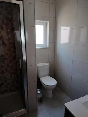 a bathroom with a toilet and a window and a shower at Casa Baptista in Vila do Bispo