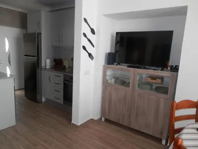 a living room with a flat screen tv on a cabinet at Casa Baptista in Vila do Bispo