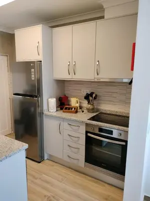 a kitchen with white cabinets and a stainless steel refrigerator at Casa Baptista in Vila do Bispo