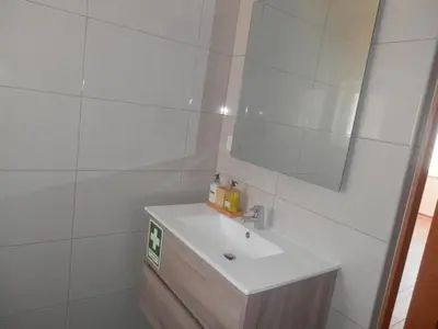a white bathroom with a sink and a mirror at Casa Baptista in Vila do Bispo