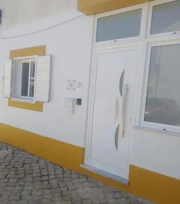 a white door on a building with a window at Casa Baptista in Vila do Bispo