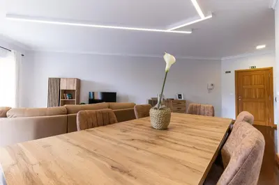 a dining room table with a flower in a vase on it at Ocean View Flat in Câmara de Lobos