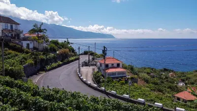 a winding road next to the ocean with houses at My School I by Atlantic Holiday in Ponta Delgada