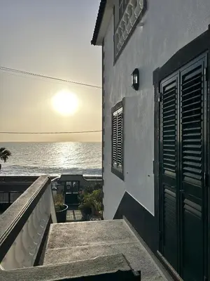 a building with a door and a view of the ocean at Casa Carneirinho by Olá Madeira in Paul do Mar