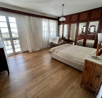 a bedroom with a bed and wooden floors and windows at Casa Carneirinho by Olá Madeira in Paul do Mar