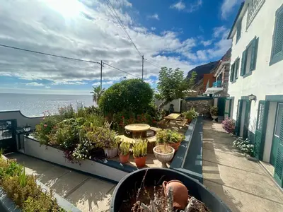 a balcony with a bunch of potted plants and the ocean at Casa Carneirinho by Olá Madeira in Paul do Mar