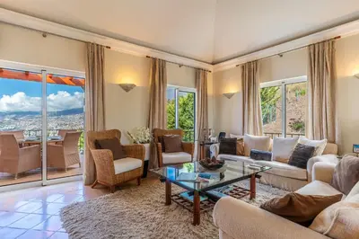 a living room with a couch and chairs and windows at Balancal Apartments and Villas Palheiro Village by Holiday Rental Madeira in Funchal
