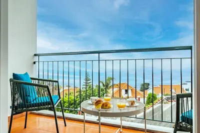 a balcony with a table with food and drinks on it at Ocean view Madeira in Caniço