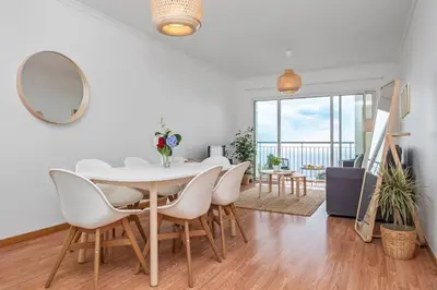 a white dining room with a white table and chairs at Ocean view Madeira in Caniço