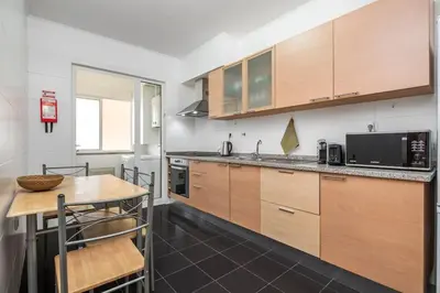 a kitchen with wooden cabinets and a wooden table at Ocean view Madeira in Caniço