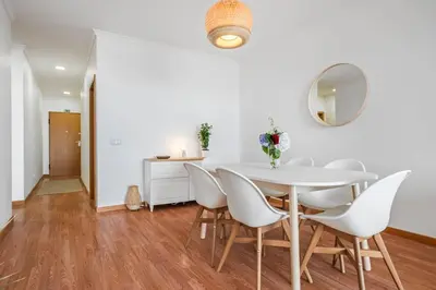 a white dining room with a white table and chairs at Ocean view Madeira in Caniço