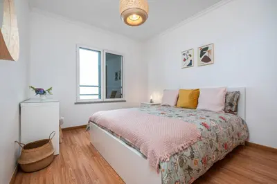 a white bedroom with a bed and a window at Ocean view Madeira in Caniço