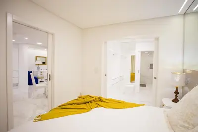 a white bedroom with a bed with a yellow blanket on it at Pérola dos Anjos by LovelyStay in Funchal