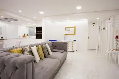 a living room with a gray couch and a kitchen at Pérola dos Anjos by LovelyStay in Funchal