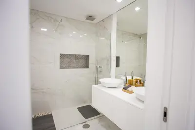 a white bathroom with a sink and a mirror at Pérola dos Anjos by LovelyStay in Funchal