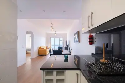 a kitchen with a counter top and a living room at Tucha's Apartement in Funchal