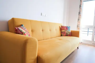 a yellow couch with two pillows on it in a room at Tucha's Apartement in Funchal