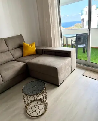 a living room with a couch and a table at Lido Casa by Olá Madeira in Funchal
