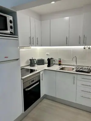 a white kitchen with a sink and a microwave at Lido Casa by Olá Madeira in Funchal