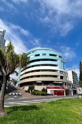 a blue building with a palm tree in front of it at Lido Casa by Olá Madeira in Funchal
