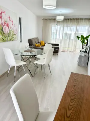 a living room with a glass table and white chairs at Lido Casa by Olá Madeira in Funchal