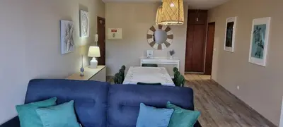 a living room with a blue couch and a table at Marear in Porto Santo