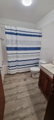 a bathroom with a toilet and a shower curtain at Marear in Porto Santo