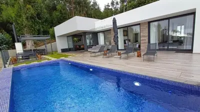 a swimming pool in front of a house at Casa da Arvore im Eukalyptuswald in Cova do Moirão