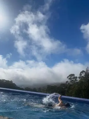 a person swimming in a swimming pool at Casa da Arvore im Eukalyptuswald in Cova do Moirão