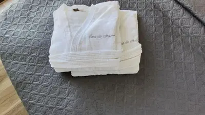 a pile of towels sitting on top of a bed at Casa da Arvore im Eukalyptuswald in Cova do Moirão