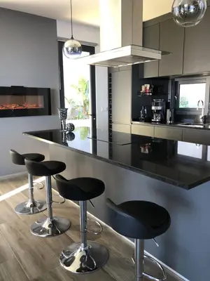 a kitchen with black counter stools and a black counter top at Casa da Arvore im Eukalyptuswald in Cova do Moirão