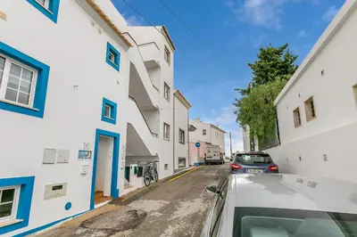 a car parked on a street between two white buildings at Bela Vista Burgau in Burgau