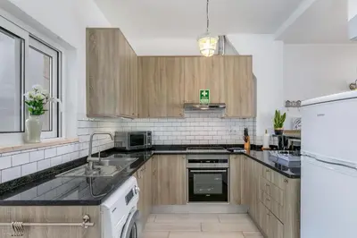 a kitchen with wooden cabinets and a white refrigerator at Bela Vista Burgau in Burgau