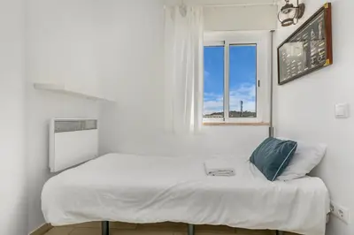 a bed in a white room with a window at Bela Vista Burgau in Burgau