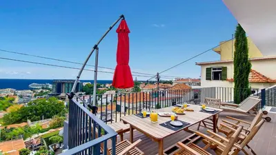 a table on a balcony with a view of the ocean at Costa Vista by LovelyStay in Funchal