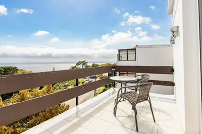a patio with a table and a chair on a balcony at The Great Pearl Ocean Views Near Beach & Airport in Machico