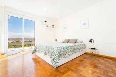 a white bedroom with a bed and a large window at The Great Pearl Ocean Views Near Beach & Airport in Machico