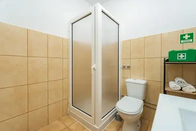 a bathroom with a toilet and a glass shower at The Great Pearl Ocean Views Near Beach & Airport in Machico