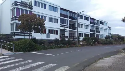 an empty street in front of a large white building at The Great Pearl Ocean Views Near Beach & Airport in Machico