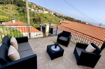 a patio with a couch and chairs and a table at Casa Gomes in Calheta