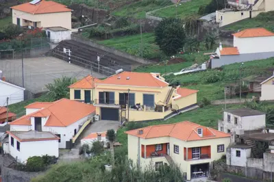 a group of houses with orange roofs on a hill at Casa Gomes in Calheta