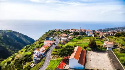 a small town on a hill with a road at Casa Gomes in Calheta