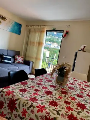 a living room with a table with a flowered table cloth at Casa Gomes in Calheta