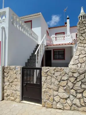 a white house with stairs and a stone wall at Amar Mar in Vila do Bispo