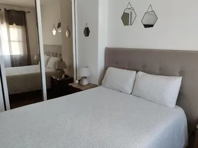 a bedroom with a white bed and a mirror at Amar Mar in Vila do Bispo
