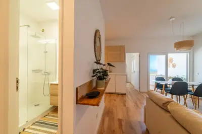 a living room with a couch and a dining room at Arrifana Sunset & Ocean View in Aljezur