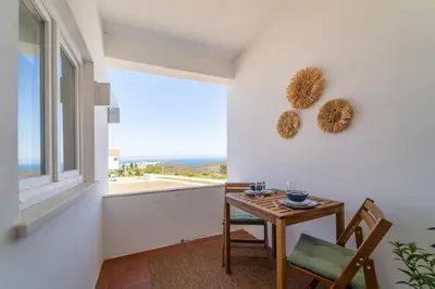 a dining room with a table and a window at Arrifana Sunset & Ocean View in Aljezur