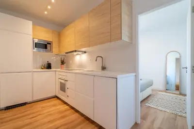 a kitchen with white cabinets and wood floors at Arrifana Sunset & Ocean View in Aljezur