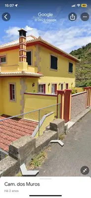 a yellow house with a fence in front of it at caminho da praia da maiata in Porto da Cruz